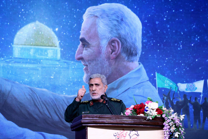 The commander of the Quds Force of the Islamic Revolutionary Guard Corps, Esmail Qaani, speaks during a commemoration ceremony marking the anniversary of the 2020 killing of Guards general Qasem Soleimani (on screen) in Tehran on January 3, 2024. (AFP)
