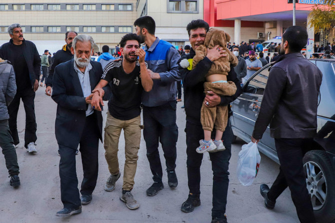 People injured in two explosions that struck a crowd marking the anniversary of the 2020 killing of Guards general Qasem Soleimani, are helped outside a hospital in the southern Iranian city of Kerman on January 3, 2024. (AFP/File)