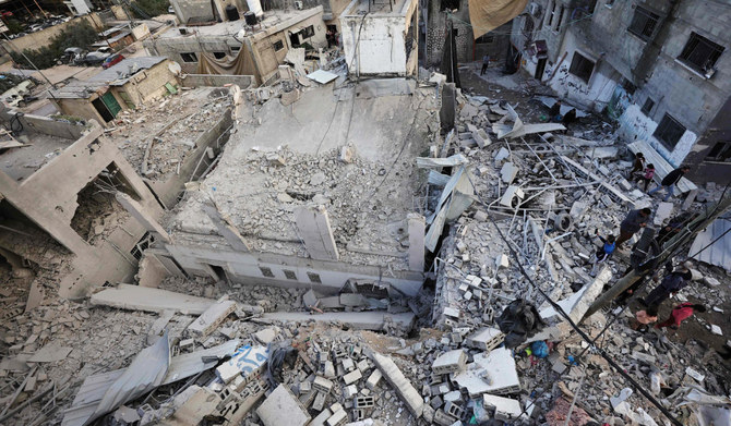 People stand amid the rubble of a building destroyed during an Israeli raid at the Nur Shams camp for Palestinian refugees near the occupied West Bank city of Tulkarm, on January 4, 2024. (AFP)