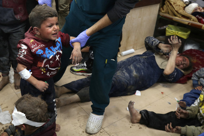 ​Palestinians injured in an Israeli airstrike on the al-Maghazi refugee camp, Gaza Strip, on Dec. 6, 2023, receive care at Al-Aqsa hospital in Deir Balah. (AFP)