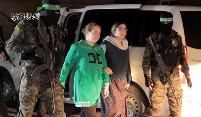 Nili Margalit and Shani Goren, hostages who were abducted by Hamas gunmen during the October 7 attack on Israel, are handed over by Hamas militants to the International Red Cross, as part of a hostages-prisoners swap deal between Hamas and Israel amid a temporary truce, in an unknown location in the Gaza Strip, November 30, 2023. (REUTERS)