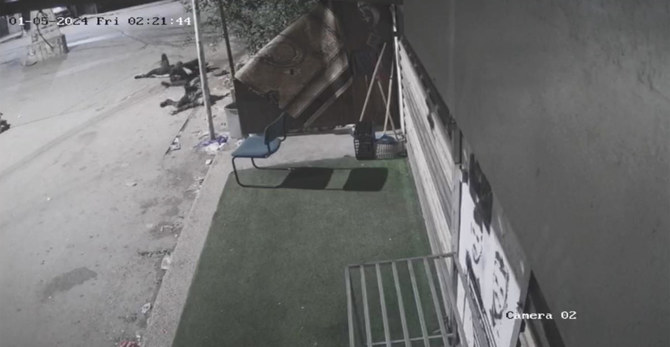 In this grab taken from security camera footage in the early hours of Friday, Jan. 5, 2024, three men lie on the ground after Israeli soldiers opened fire, in the occupied West Bank village of Beit Rima. (UGC via AP)