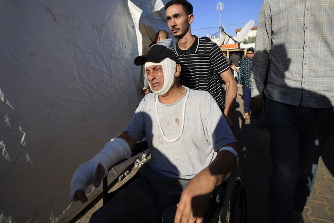 A Palestinian man wounded in Israeli bombardment reacts as he is wheeled outside Al-Aqsa hospital in Deir al-Balah in the centre of the Gaza. (File/AFP)