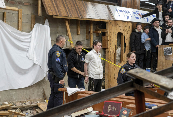 New York Police officers arrest a Hasidic Jewish student after he was removed from a breach in the wall of the synagogue that led to a tunnel dug by students in New York on Jan. 8, 2024. (Bruce Schaff via AP)