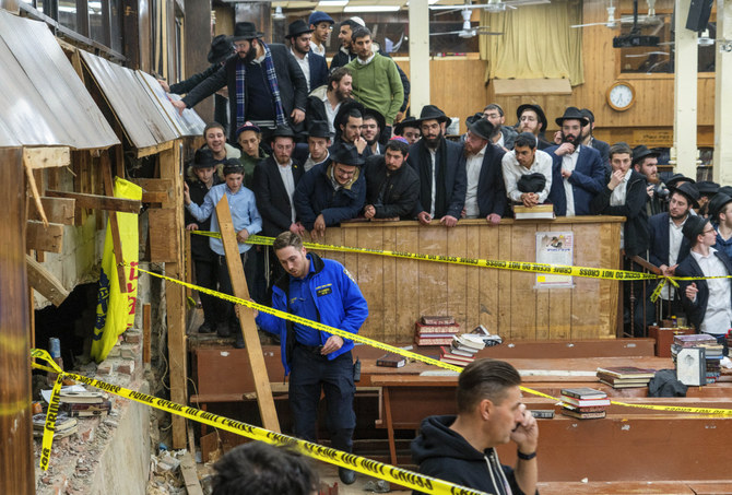 New York Police officers conceal the breach in the wall of the synagogue that led to a tunnel dug by Hasidic Jewish students in New York on Jan. 8, 2024. (Bruce Schaff via AP)