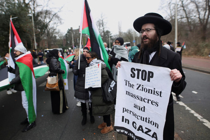 A Jewish demonstrator holds a placard on the day judges of the International Court of Justice (ICJ) hear a request for emergency measures to order Israel to stop its military actions in Gaza, in The Hague (REUTERS)