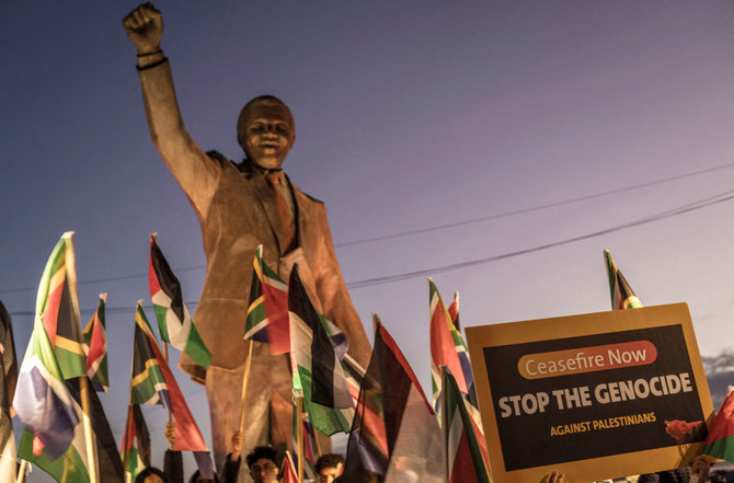 Demonstrators gather around a statue of late President Nelson Mandela in the occupied West Bank city of Ramallah to celebrate a landmark ‘genocide’ case filed by South Africa against Israel at the International Court of Justice. (AFP)