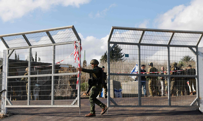 Israeli soldiers are stationed at the entrance of Kfar Yuval in northern Israel near the Lebanon border, after it was reportedly targeted with an anti-tank missile from the Lebanese side on January 14, 2024. (AFP)