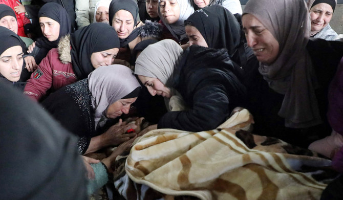 Relatives mourn over one body during the funeral of Ahmed and Jalal Jabarin, who were shot dead by Israeli troops when their car broke through a checkpoint near the city of Hebron, in the southern West Bank village of Sair, east of Hebron, on January 15, 2024. (AFP)