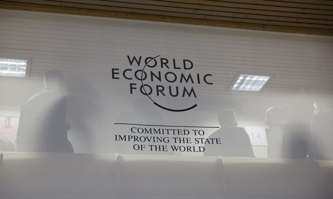 People stand behind a logo of the World Economic Forum during the 54th annual meeting in Davos, Switzerland, January 16, 2024. (Reuters)