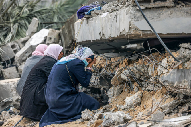 Palestinian women mourn for a relative buried in debris following Israeli bombardment in Rafah in the southern Gaza Strip on December 21, 2023. (AFP)