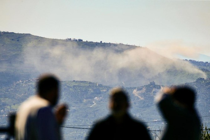 People watch as smoke billows over hills near the southern Lebanese village of Odaisseh on the border with Israel as fighting continues between Israel and the Palestinian militant group Hamas in Gaza. (AFP)