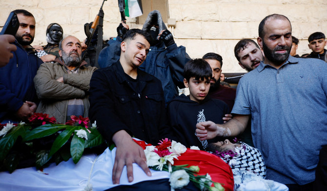 Palestinians mourn the loss of Tawfiq Ajaq, 17, during his funeral near Ramallah on Saturday. The Palestinian American teenager was killed in Israeli attack. (Reuters)