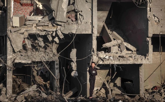 A Palestinian man stands in front of a building destroyed by Israeli strikes, Rafah, southern Gaza Strip, Jan. 24, 2024. (AFP)