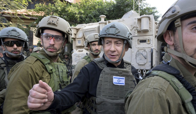 Israeli Prime Minister Benjamin Netanyahu, center, wears a protective vest and helmet as he receives a security briefing with commanders and soldiers in the northern Gaza Strip, on Monday, Dec. 25, 2023. (AP)