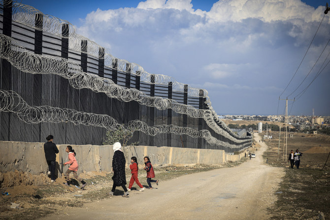 Displaced Palestinians walk along the Egyptian border, west of Rafah in the southern Gaza Strip on January 14. (File/AFP)