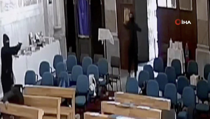 A screenshot from video footage taken from a CCTV camera shows two masked men holding guns inside Santa Maria church in Istanbul, Turkey, on Jan. 28, 2024. (IHA via AP)