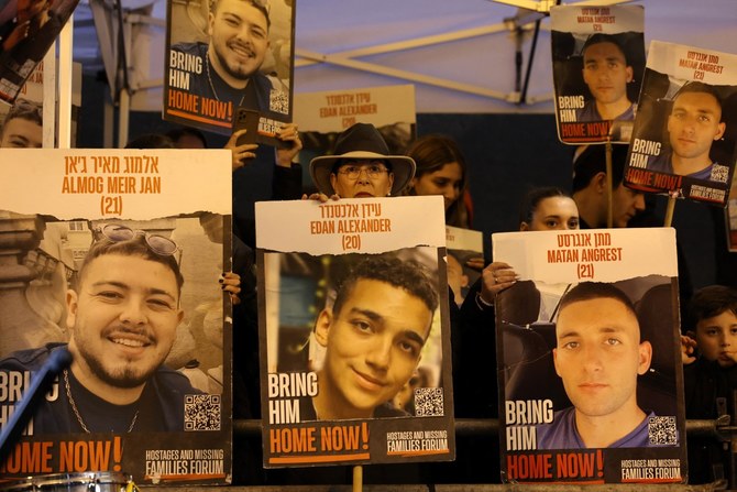 Relatives and supporters hold placards bearing portraits of Israeli hostages (AFP)