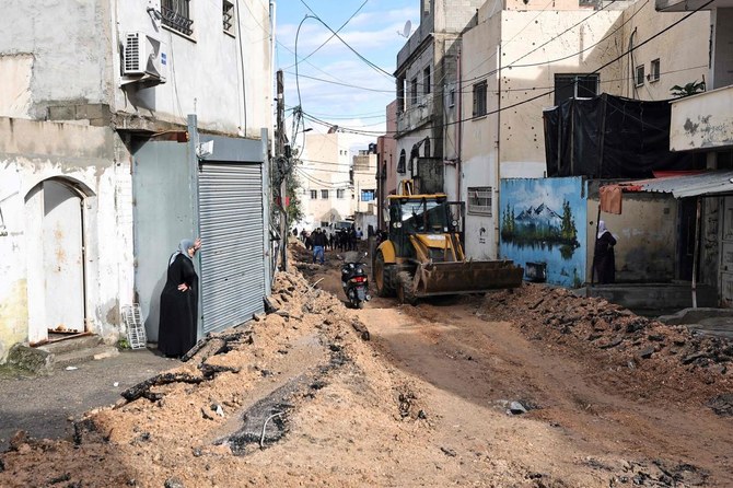 Palestinian women stand on the side of a street which has been bulldozed by the Israeli forces during a raid in Jenin in the occupied West Bank on Jan. 29, 2024. (AFP)