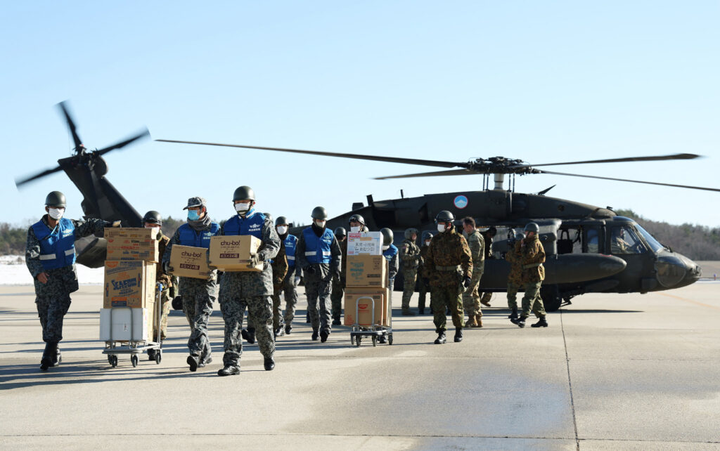 Elderly evacuees and others are arriving by helicopter at a staging care unit, which was set up at a parking lot near temporary evacuation centers in Kanazawa, the capital of Ishikawa. (AFP)