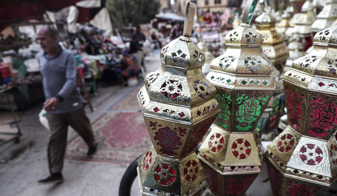 An Egyptian man walks past traditional lanterns known in Arabic as 