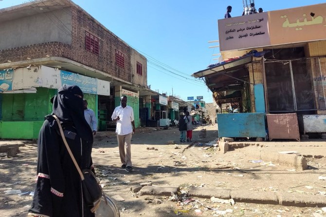 Sudanese civilians walk through a nearly empty road with many shops closed for security reasons in Gedaref city in eastern Sudan. Gedaref currently hosts 273,000 people uprooted in the conflict between the Sudanese army and paramilitary Rapid Support Forces (RSF) which broke out in April last year. (AFP)