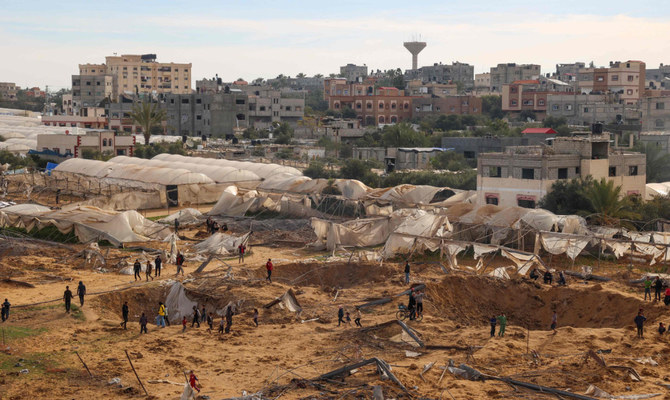 People stand around craters caused by Israeli bombardment in Rafah on the southern Gaza Strip on February 12, 2024. (AFP)