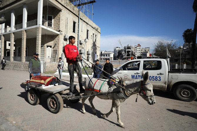 A Palestinian youth transports a body in a donkey-pulled cart, near the Ahli Arabi hospital in Gaza City, on January 31, 2024, amid the ongoing conflict between Israel and the Palestinian militant group Hamas. (Photo by AFP)