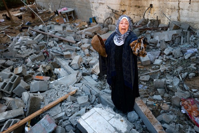 A woman reacts upon finding clothing items of a killed relative among rubble of a destroyed house, following Israeli bombardment in Rafah in the southern Gaza Strip (AFP)