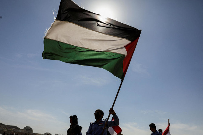 Houthi followers hold a Palestinian flag during a parade in solidarity with the Palestinians in the Gaza Strip and to show support to Houthi strikes on ships in the Red Sea and the Gulf of Aden, in Sanaa. (File/Reuters)