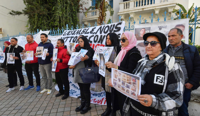 Families of people from al-Hansha in Tunisia's Sfax province who went missing at sea in irregular migration attempts, lift portraits and placards calling on the government to support efforts to find out what happened to their relatives during a rally in Tunis on February 6, 2024. (AFP)