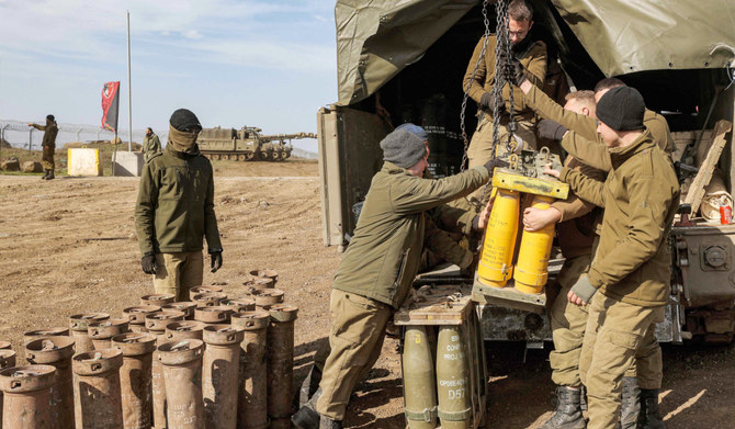 Israeli soldiers transport munitions off a vehicle at a position in the Israeli-annexed Golan Heights on January 2, 2023. (AFP)