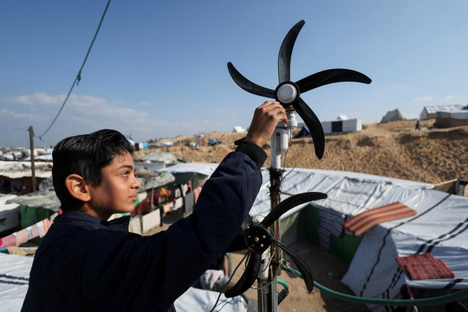 Teenager Hussam Al-Attar has created his own source of electricity to light up the tent where he and his family are living after being displaced by Israel’s assault on Gaza. (Reuters)