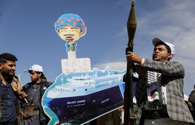 A Houthi fighter brandishes a rocket launcher in front of a depiction of the Galaxy Leader cargo ship, which was seized by the Houthis, Sanaa, Yemen, Feb. 7, 2024. (Reuters)