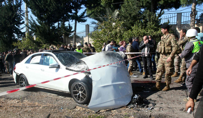 Blood stains cover the ground next to a a car wrecked in a reported Israeli drone attack, as Lebanese army soldiers secure the area in the village of Jadra between Beirut and the southern city of Sidon, on February 10, 2024. (AFP)