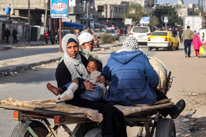 A Palestinian woman holds her injured daughter as they ride on a donkey-drawn cart toward a clinic in Rafah in the southern Gaza Strip on February 12, 2024, amid Israel's ongoing war on Gaza. (File/AFP)