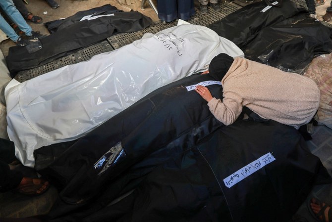 A woman mourns over the bodies of loved ones killed during Israeli bombardment at Al-Najar hospital in Rafah (AFP)