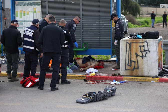 Israeli security forces surround the body of a man suspected of carrying out a shooting attack in the southern town of Kiryat Malakhi on February 16, 2024.(AFP)