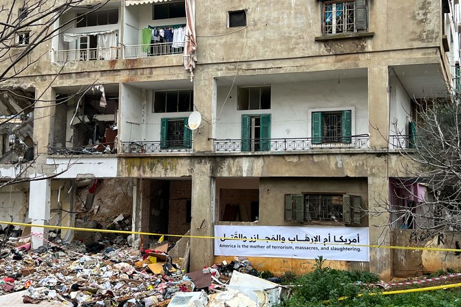 A banner hangs on the side of a building that was damaged by an Israeli air raid two days earlier in Lebanon's southern city of Nabatieyh on February 16, 2024. Israeli strikes on targets in south Lebanon killed five fighters from Hezbollah and the allied Amal movement, the groups said on February 16, adding to an uptick in violence causing international alarm. (AFP)