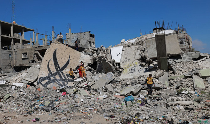 Children stand next to a fallen wall amid the rubble of a building destroyed in Israeli bombardment in Rafah in the southern Gaza Strip on February 22, 2024. (AFP/File)