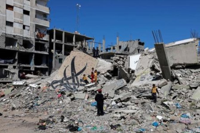 Children stand next to a fallen wall bearing a mural painting amid the rubble of a building destroyed in Israeli bombardment in Rafah on Feb. 22, 2024, amid continuing battles between Israel and Hamas. (AFP)