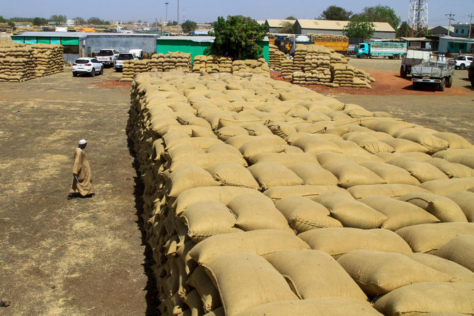 A man walks past sacks of grains at a market in Gedaref, eastern Sudan, on Feb. 22, 2024. (AFP)