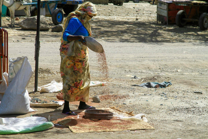 A woman winnows grains at a market in Gedaref, eastern Sudan, on Feb. 22, 2024. (AFP)