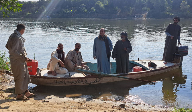 Egyptian men board a fishing boat to look for bodies by the bank of a canal after a ferry boat carrying workers sank off the town of Manshyat al-Qanater in Giza on February 25, 2024. (AFP)