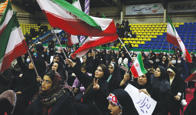 Iranian women in Tehran wave their country’s flags during an election campaign rally ahead of the March 1 elections for parliament and Assembly of Experts. (AP)