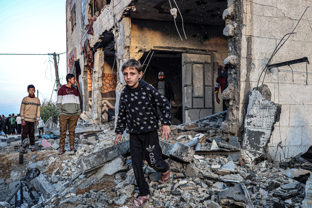 People walk through the rubble of a building heavily damaged by Israeli bombardment, in Rafah in the southern Gaza Strip on February 11, 2024, amid the ongoing conflict between Israel and the Palestinian militant group Hamas. (Photo by SAID KHATIB / AFP)