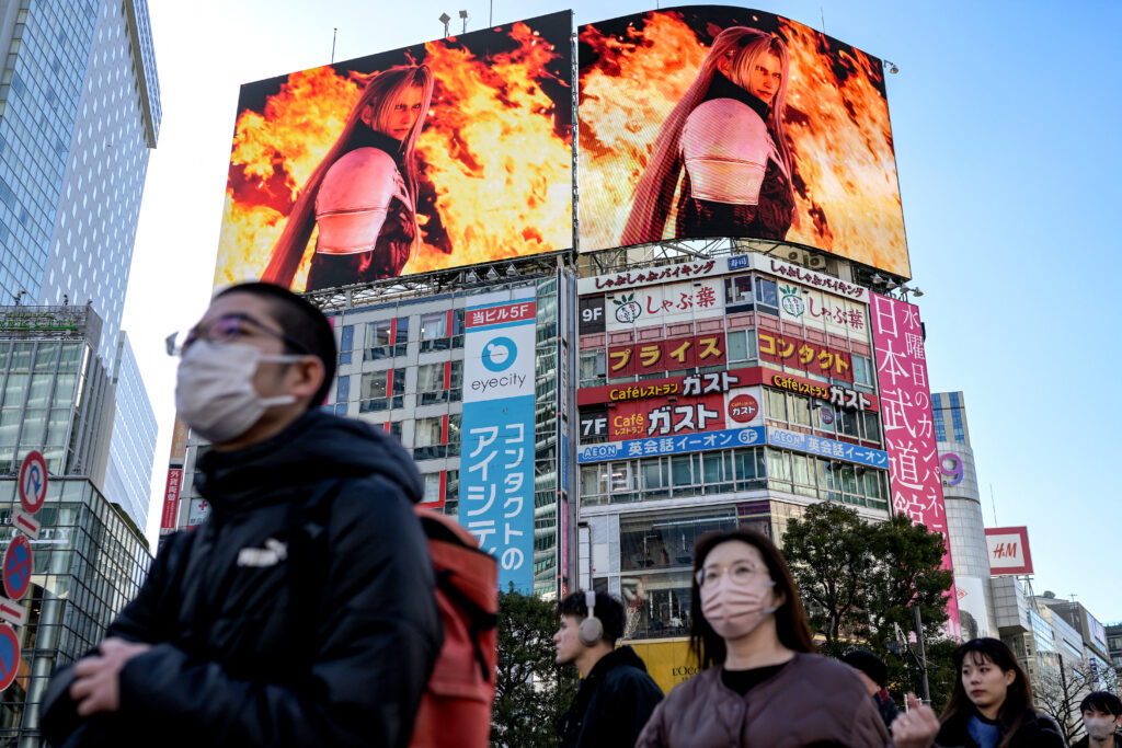 Pedestrians walk across a street as promotional videos (above) of 'Final Fantasy VII Rebirth', the latest release of the video game franchise developed and published by Japanese company Square Enix, is displayed on various screens at Shibuya Crossing in the Shibuya district of Tokyo on February 27, 2024. (AFP)