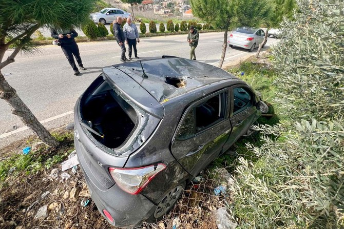 People gather near a vehicle targeted in an Israeli drone attack in the town of Bint Jbeil near the border with Israel on February 12, 2024. (AFP)