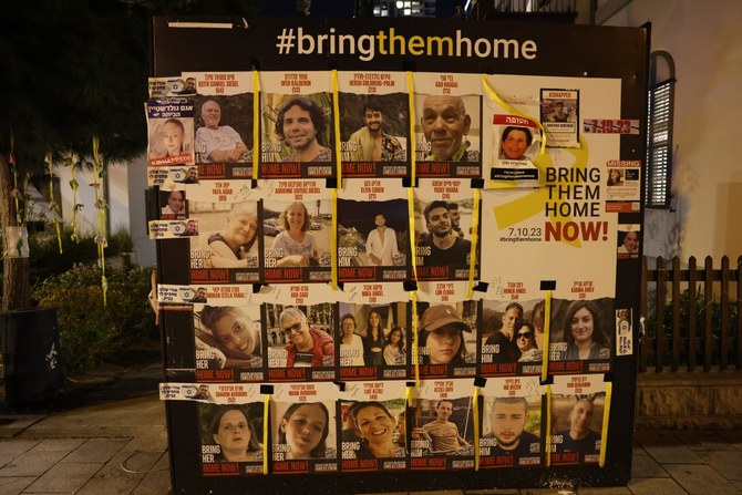Pictures of some of the Israeli hostages held in Gaza since the October 7 attacks are plastered on a street board in Tel Aviv during a protest calling for their release (AFP)