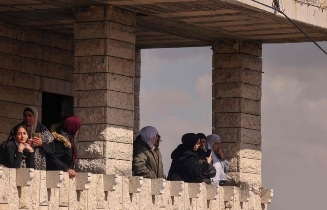 Palestinian women watch, from a balcony, the funeral of Nihil Ziad Breighith, 17, who died of wounds sustained during an Israeli raid, Beit Ummar, north of Hebron, West Bank, Feb. 15, 2024. (AFP)